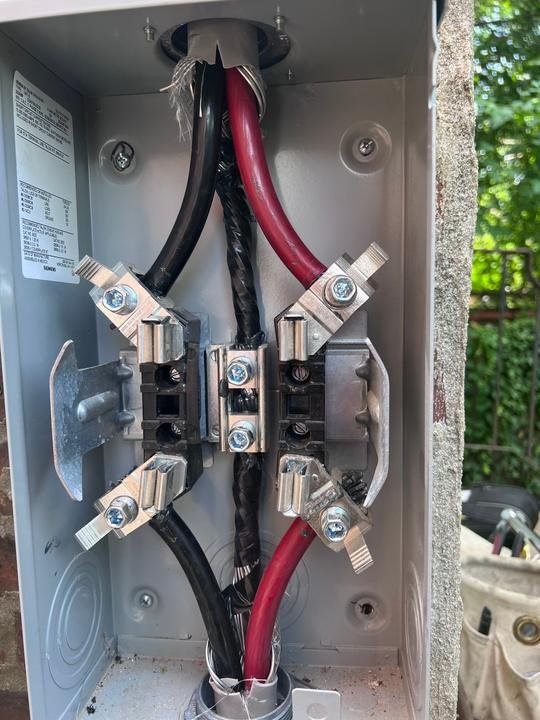 Fresh service entrance conductors landed in a new Siemens meter socket, ready for the utility meter.