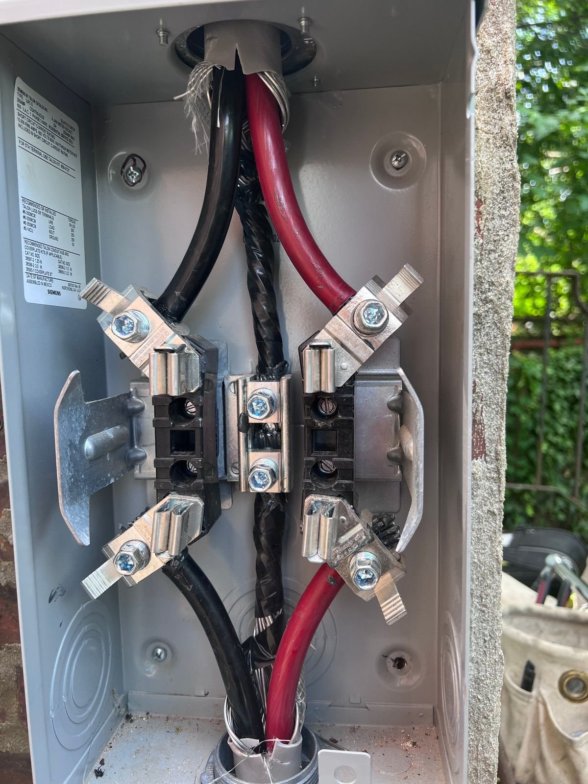 Fresh service entrance conductors landed in a new Siemens meter socket, ready for the utility meter.