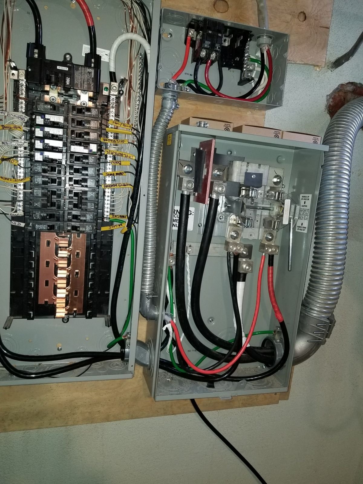 A new Siemens 200 amp panel with labeled circuits, a meter socket and a 100 amp disconnect, wired in flexible metal conduit.